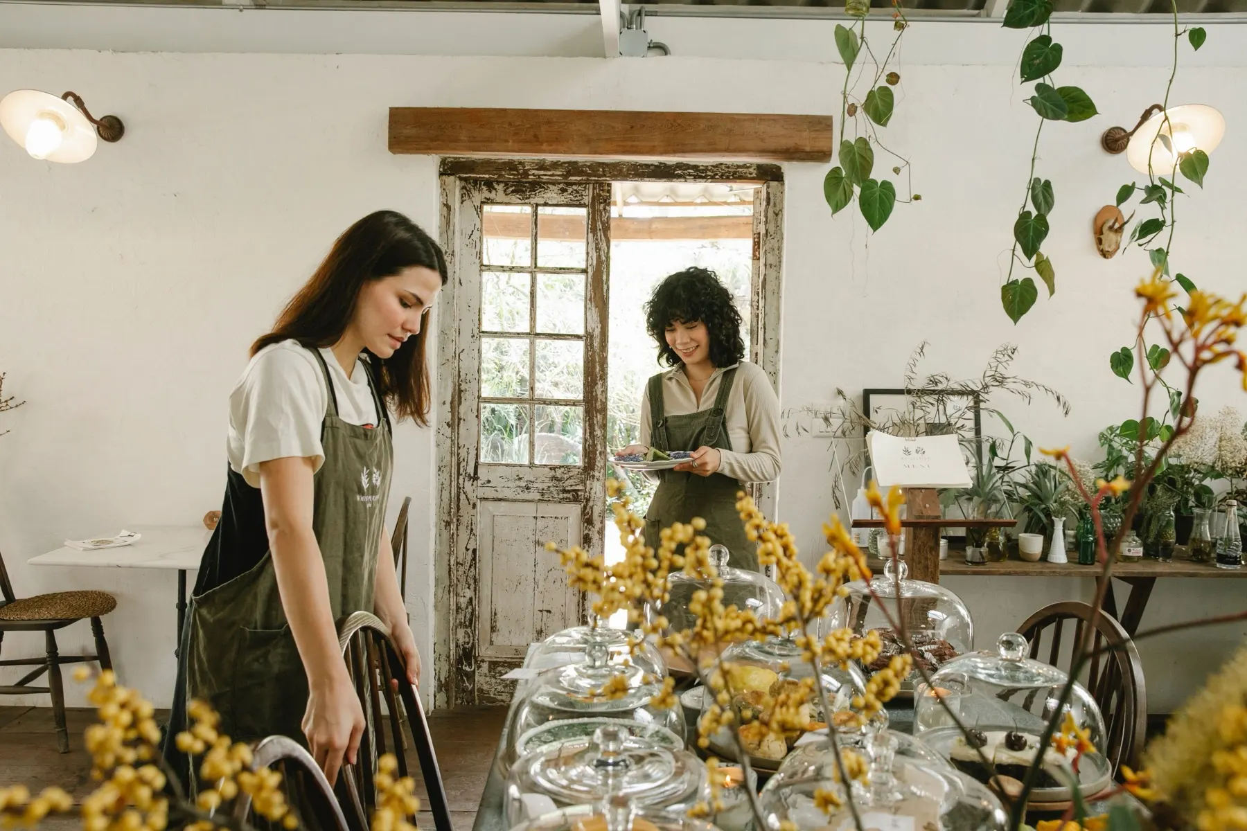 Two people preparing a small flower shop for the day's work